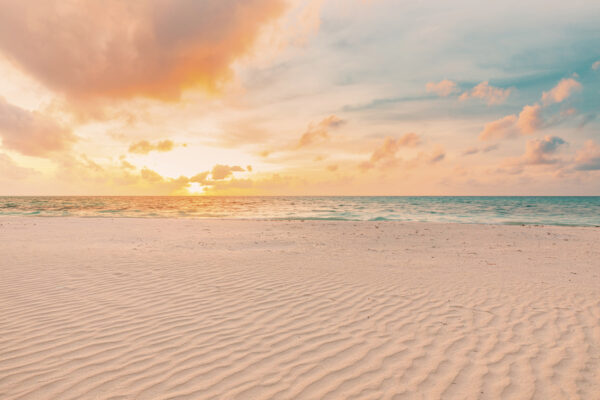 Een zandstrand met golven en een zonsondergang Een zandstrand met golven en een zonsondergang