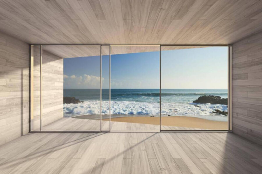 Kamer met grote glazen deuren en uitzicht op het strand