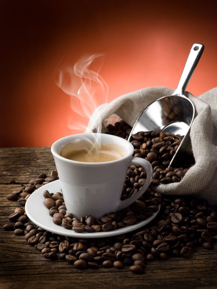 Kopje koffie met stoom en koffiebonen