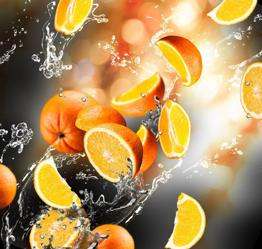 Sinaasappels die in het water vallen met opspattend water Sinaasappels die in het water vallen met opspattend water