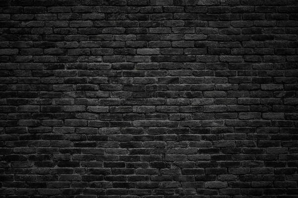 Zwarte bakstenen muur met een witte vlek Zwarte bakstenen muur met een witte vlek
