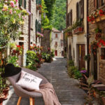 Fotobehang Smalle straat met bloemen en planten aan de zijkant