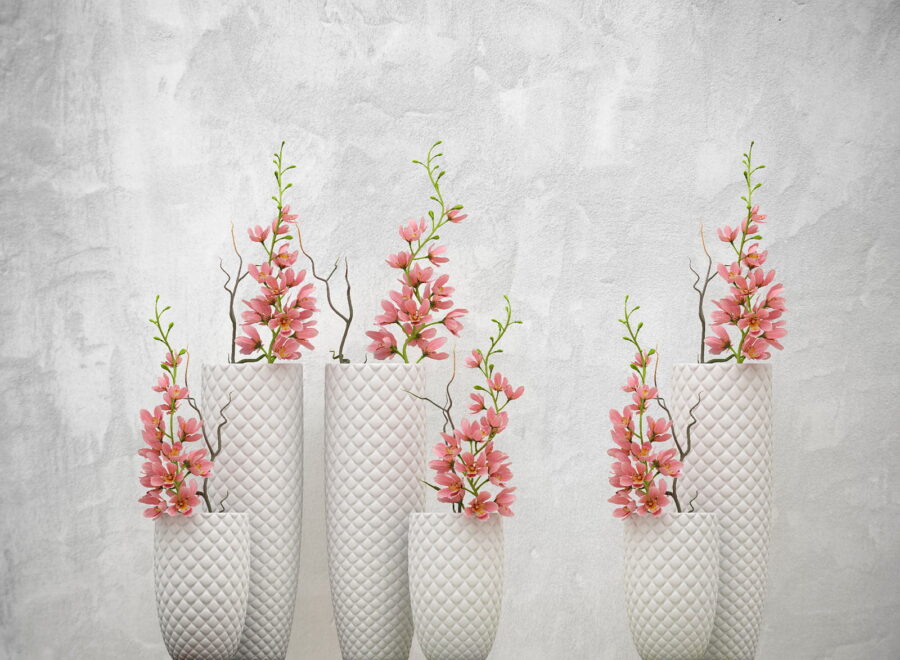 Groep witte vazen met roze bloemen