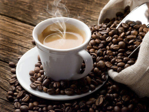 Kopje koffie op een schoteltje met koffiebonen Kopje koffie op een schoteltje met koffiebonen