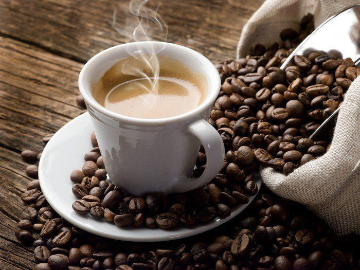Kopje koffie op een schoteltje met koffiebonen