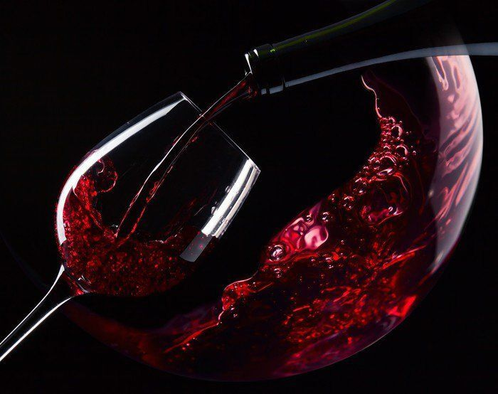 Glas rode wijn wordt ingeschonken Glas rode wijn wordt ingeschonken