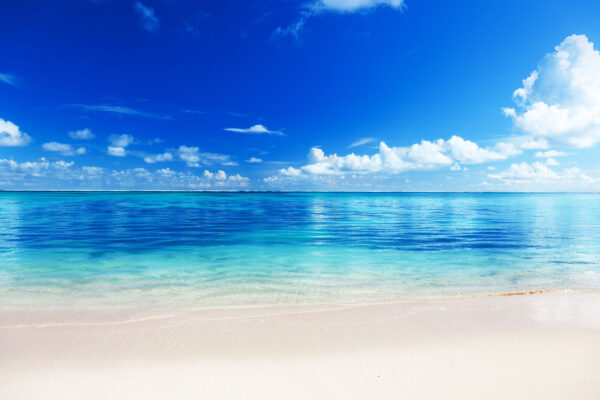 Strand met blauw water en wolken Strand met blauw water en wolken