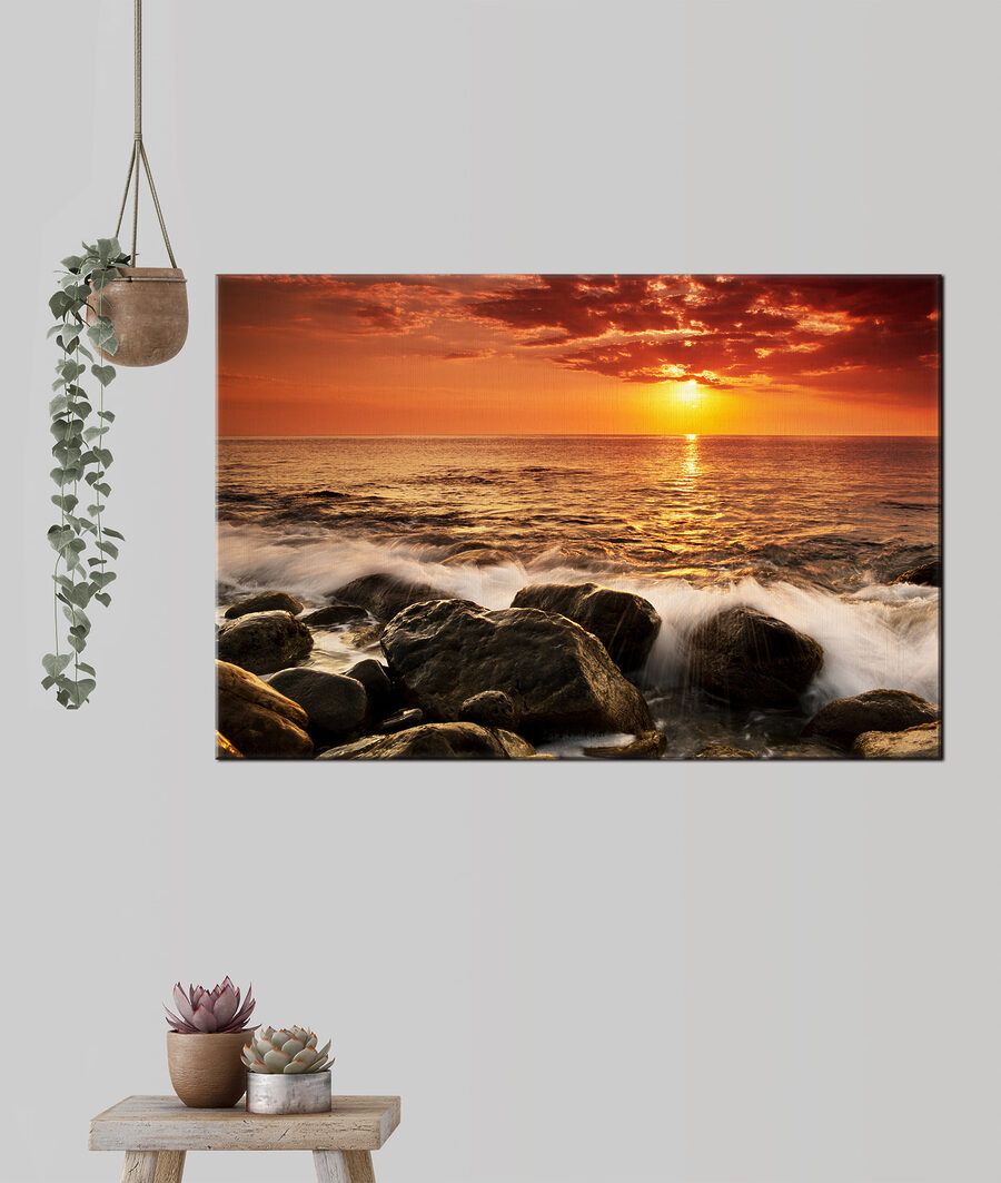 Een zonsondergang boven een rotsstrand