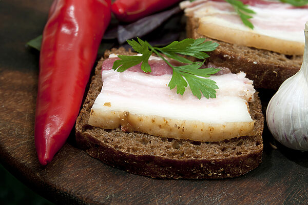 Een stuk brood met spek en peterselie erop Een stuk brood met spek en peterselie erop