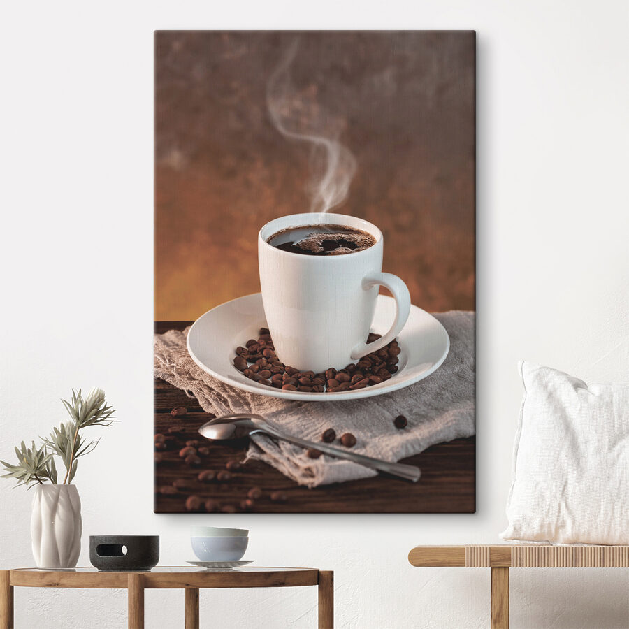 Een kop koffie op een bord met bonen en een lepel