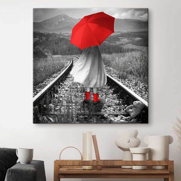 Een persoon met een rode paraplu op een treinspoor Een persoon met een rode paraplu op een treinspoor