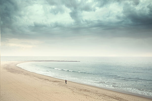 Een persoon die op een strand loopt Een persoon die op een strand loopt