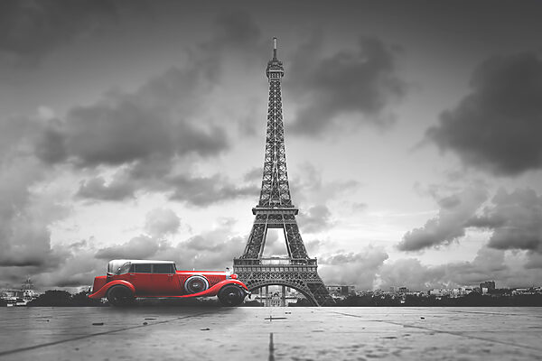 A red car parked in front of a large tower A red car parked in front of a large tower