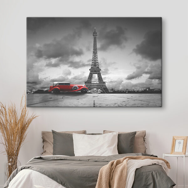A red car parked in front of a large tower A red car parked in front of a large tower