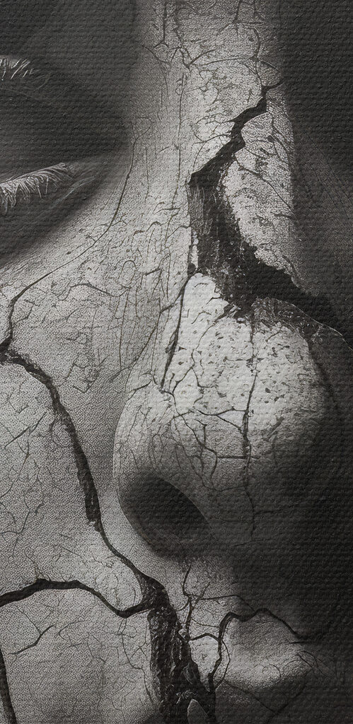 A statue of a woman with a cracked face and snakes around her face