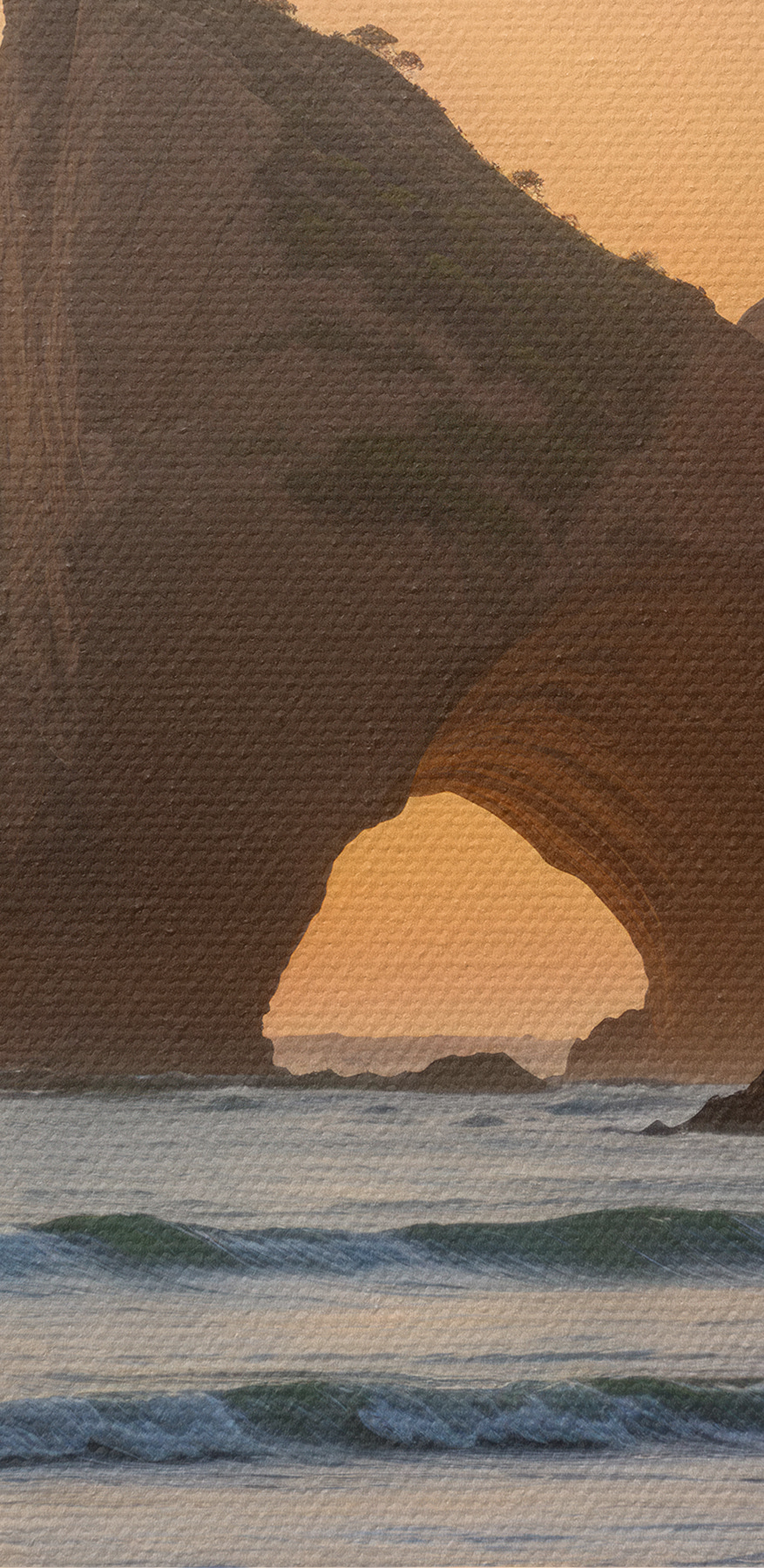 Zonsondergang over een strand met rotsen en water