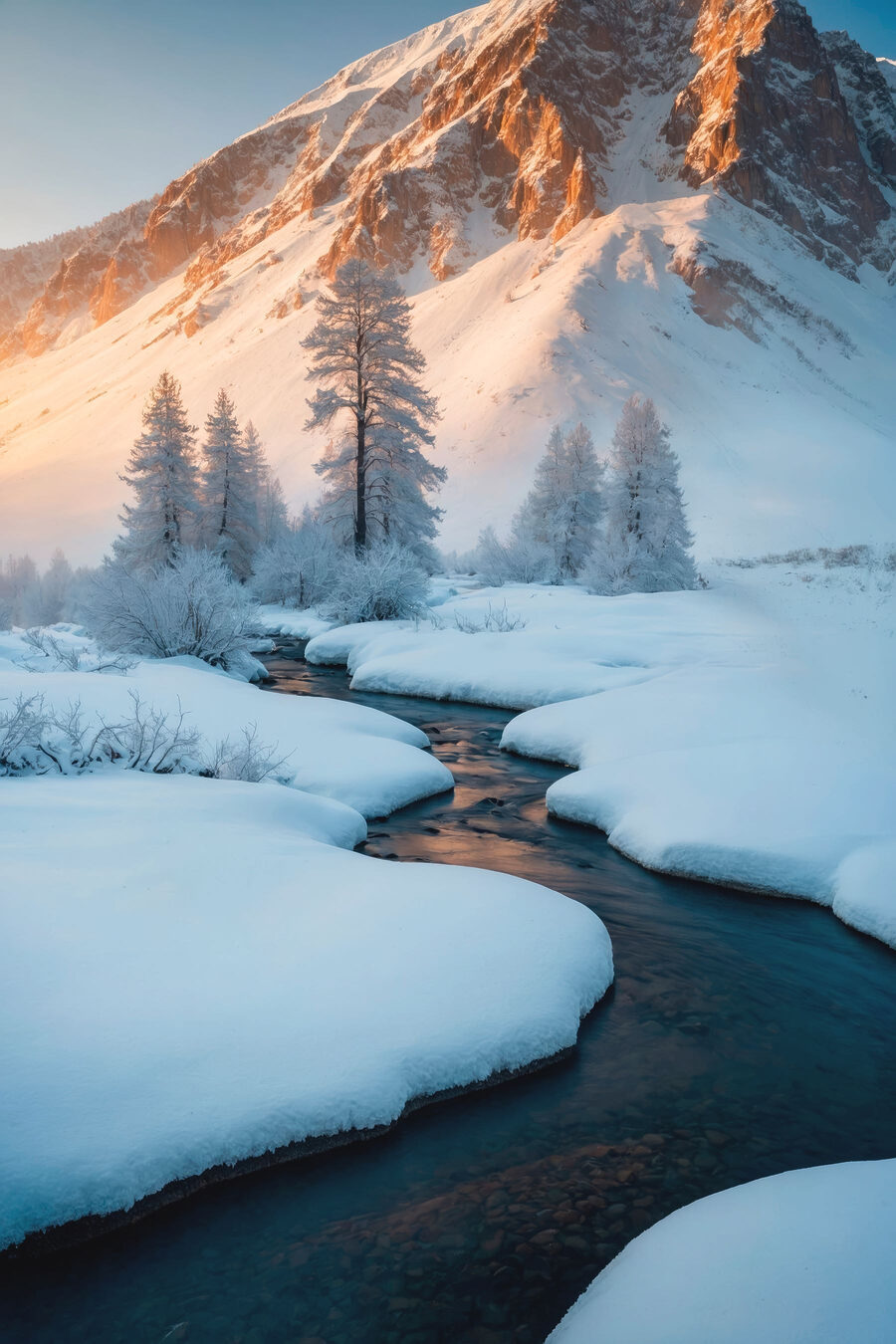 Rivier stroomt door een besneeuwde berg