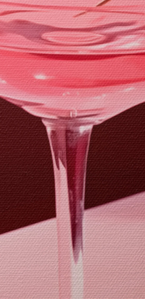 Glas met roze vloeistof en twee kersen erop Glas met roze vloeistof en twee kersen erop