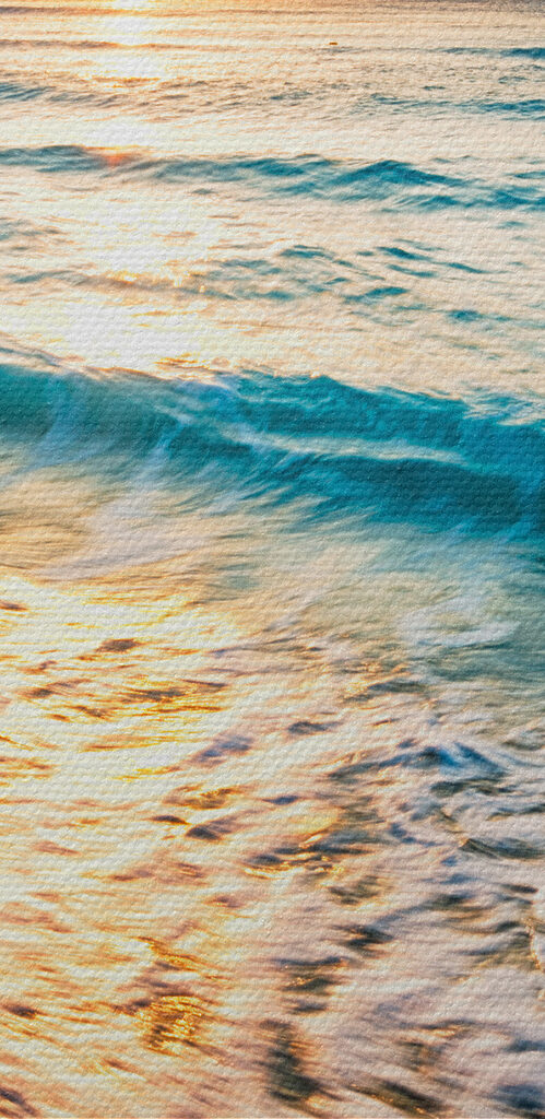A beach with waves and a sunset