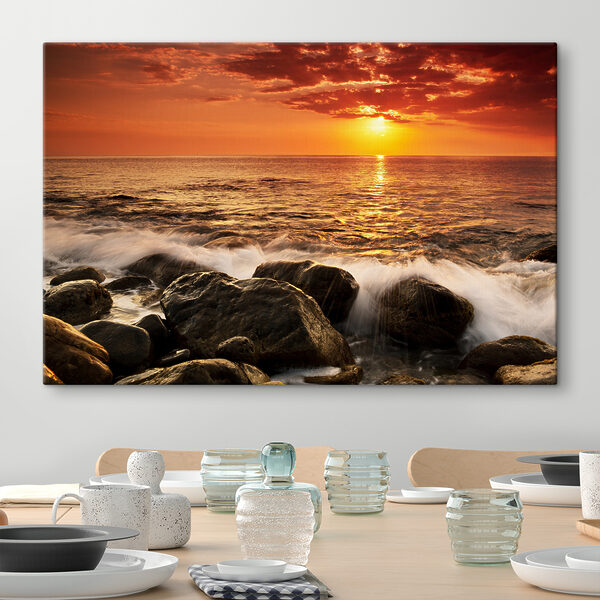 Een zonsondergang boven een rotsstrand Een zonsondergang boven een rotsstrand