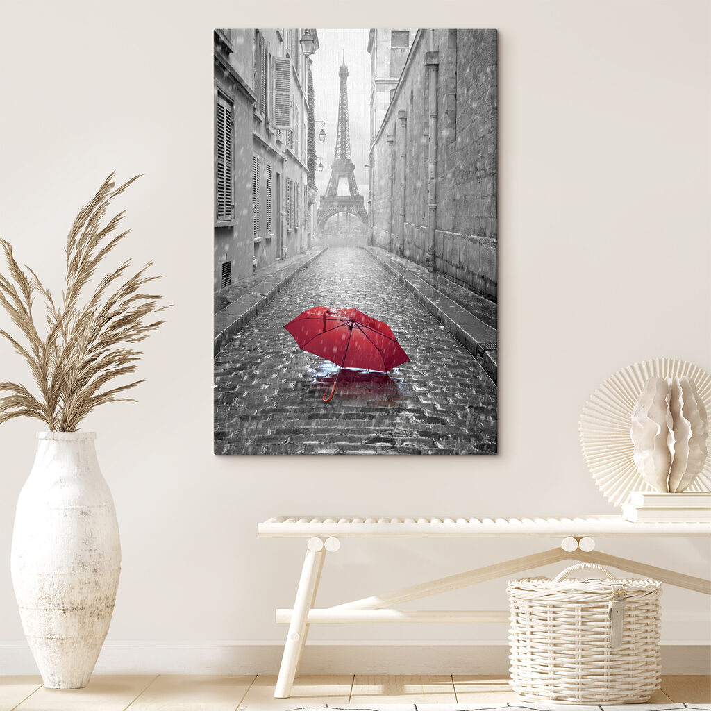 A red umbrella in a street with a tower in the background