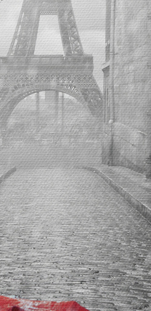 A red umbrella in a street with a tower in the background