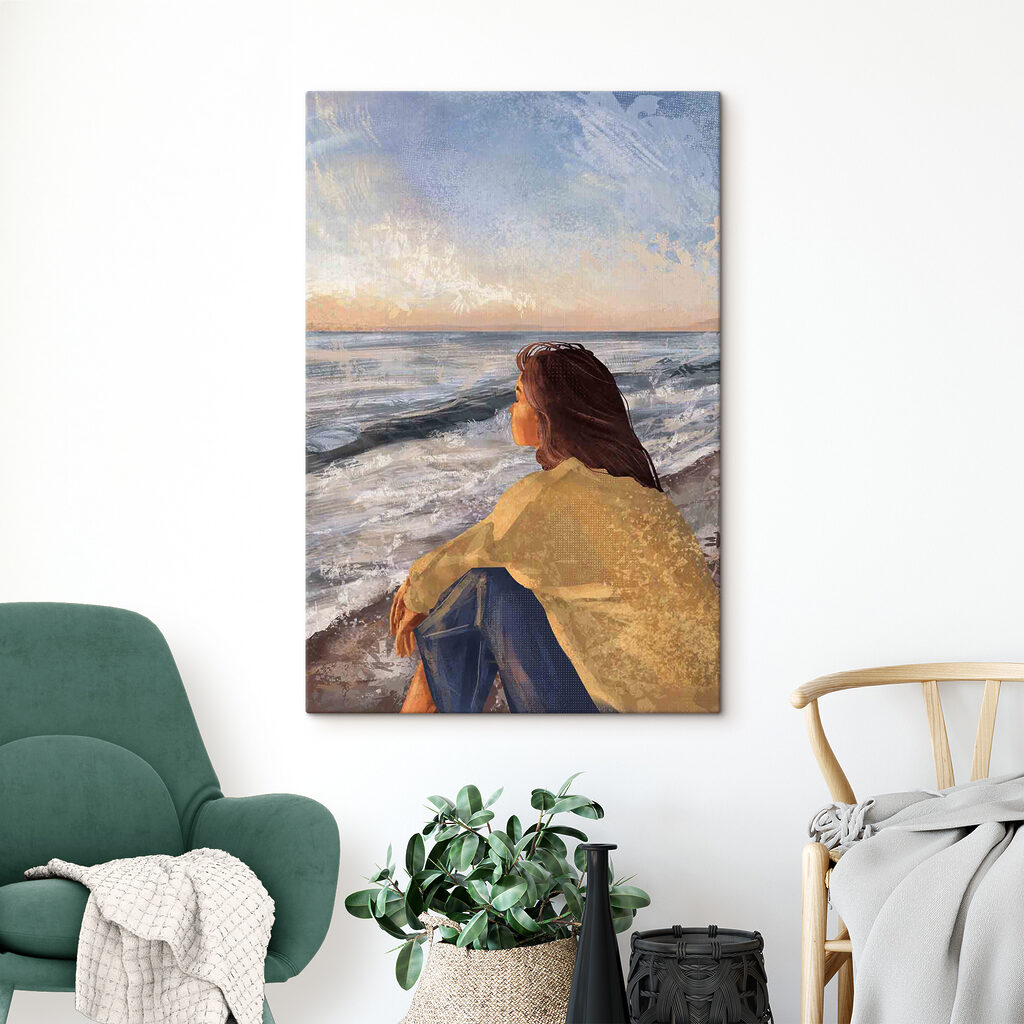 A woman sitting on a beach looking out to the ocean A woman sitting on a beach looking out to the ocean
